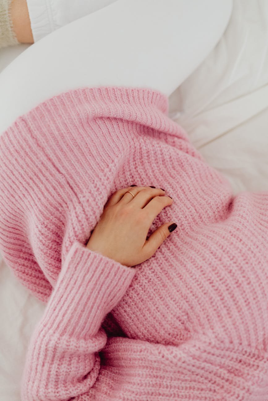 person in pink knit sweater lying down