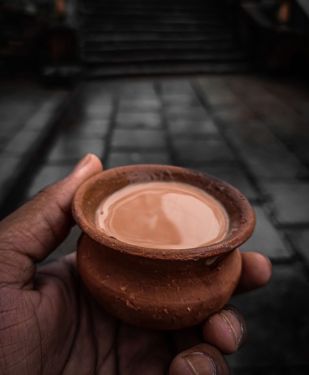 close up shot of a person holding a small clay pot