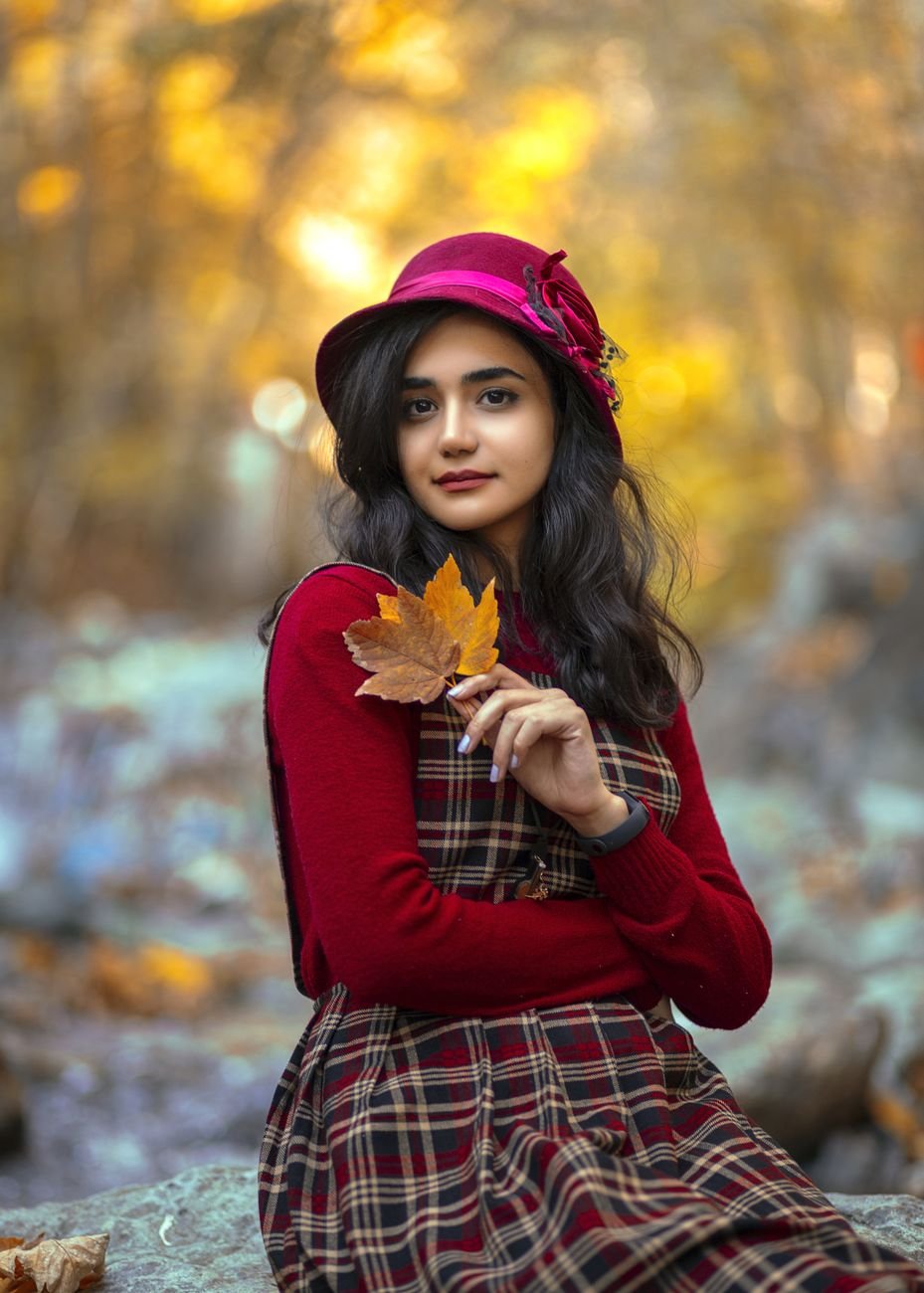 selective focus of a beautiful woman holding autumn leaves