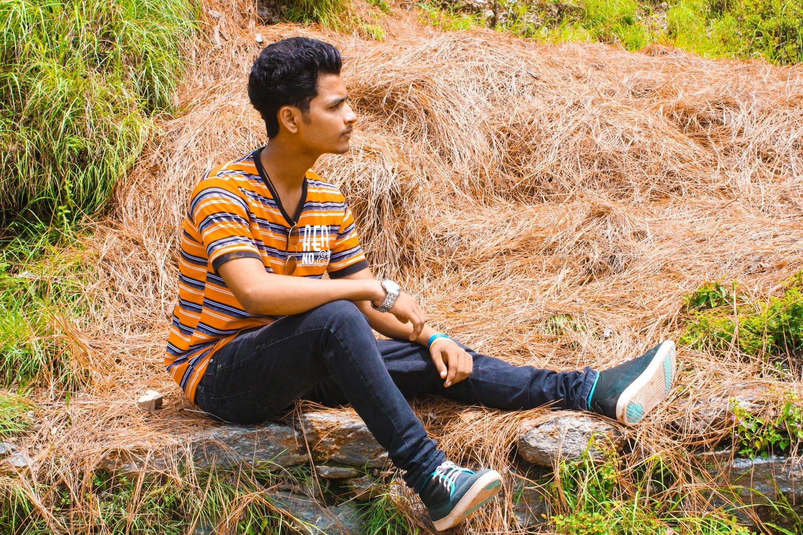 man wearing blue jeans sitting on brown hay