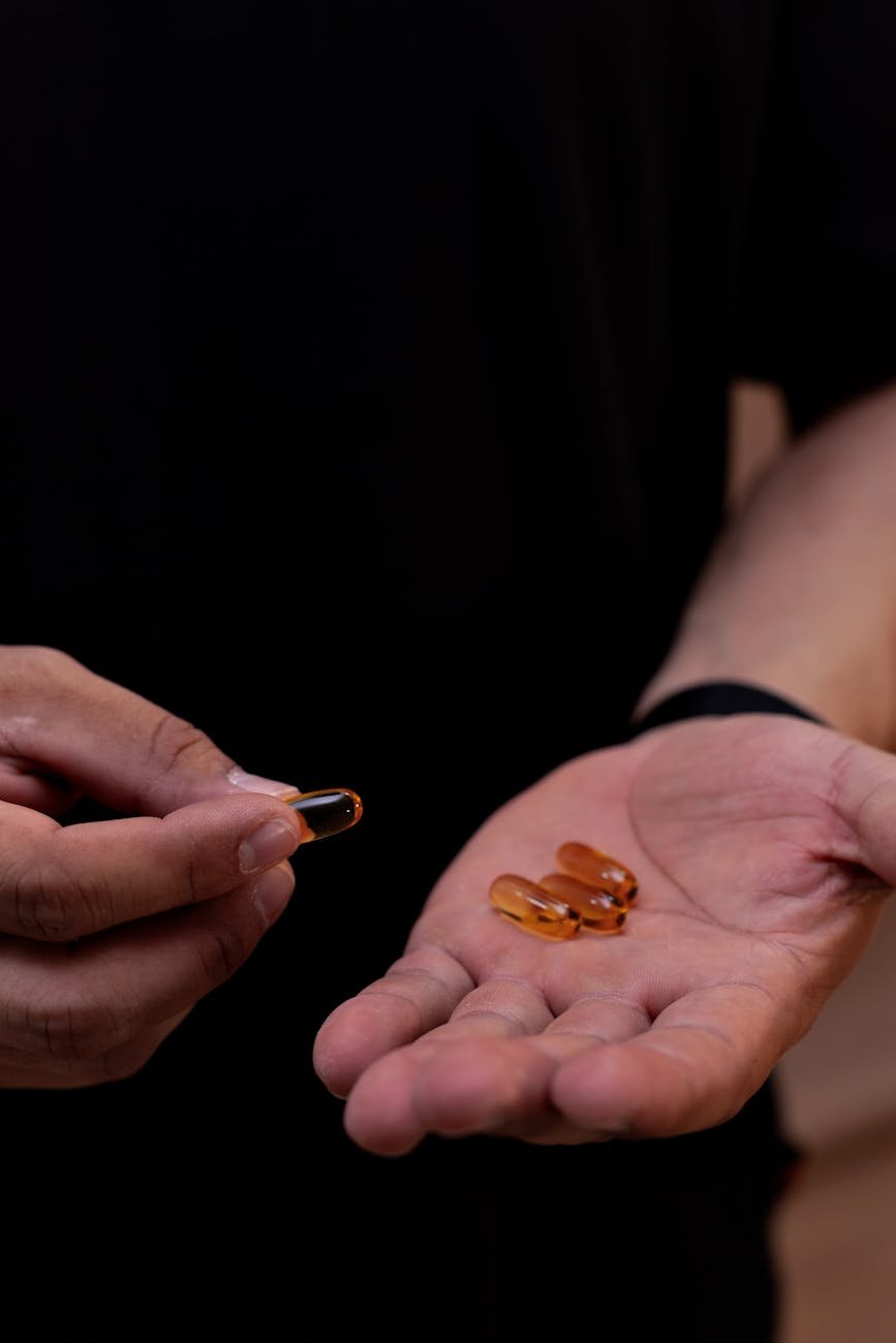 close up of hand holding vitamin capsules