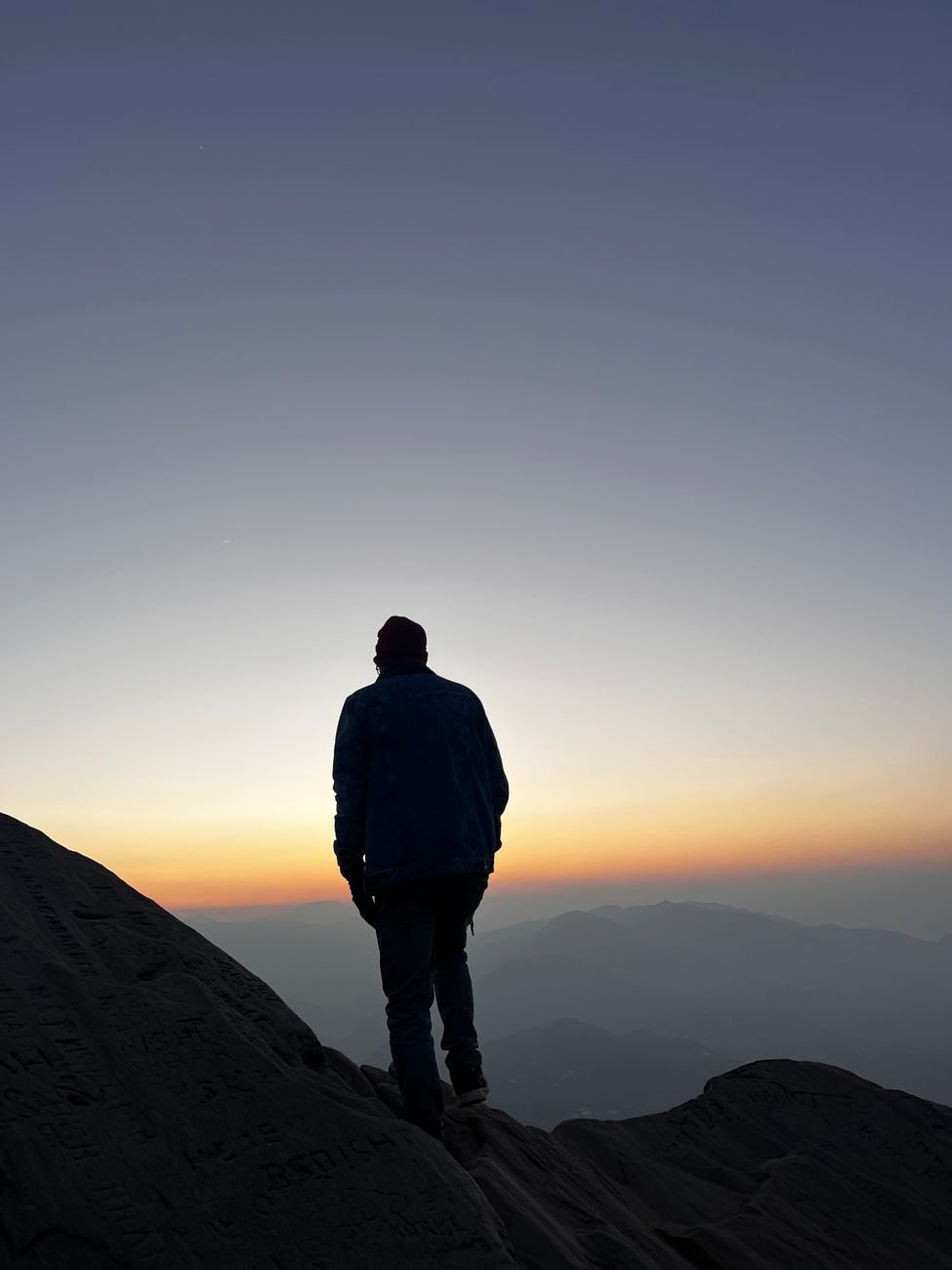 silhouette of man at sunrise on mountain peak