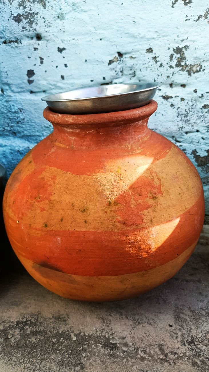 traditional clay pot with metal dish outdoors