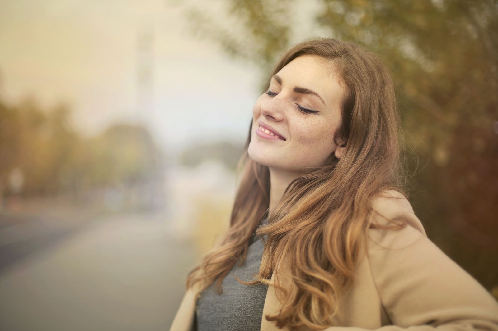 selective focus portrait photo of smiling woman with her eyes closed