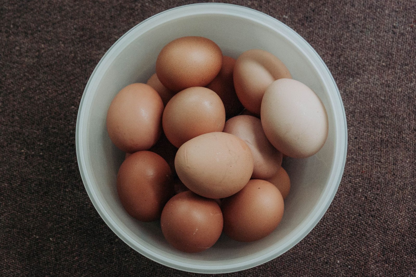 close up photo of pile of brown eggs in a bowl