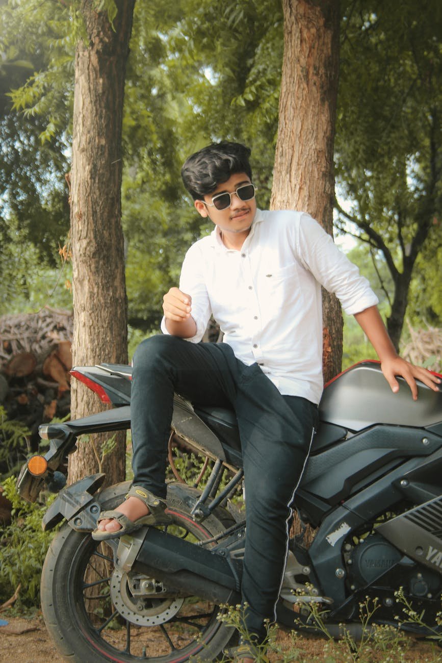 a man in white long sleeves sitting on the motorcycle