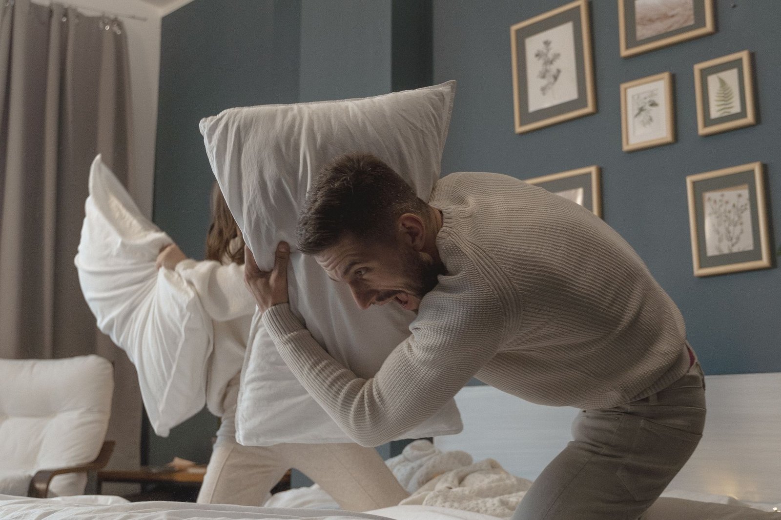 a couple having fun playing pillow fight
