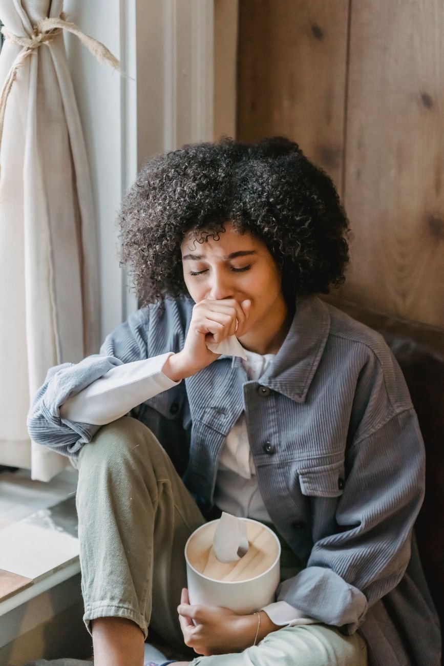 depressed young black woman sitting on hair with closed eyes and crying