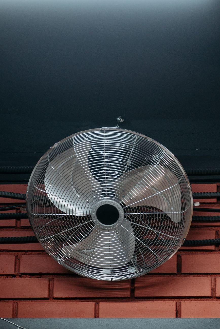 ceiling fan beside a brick wall