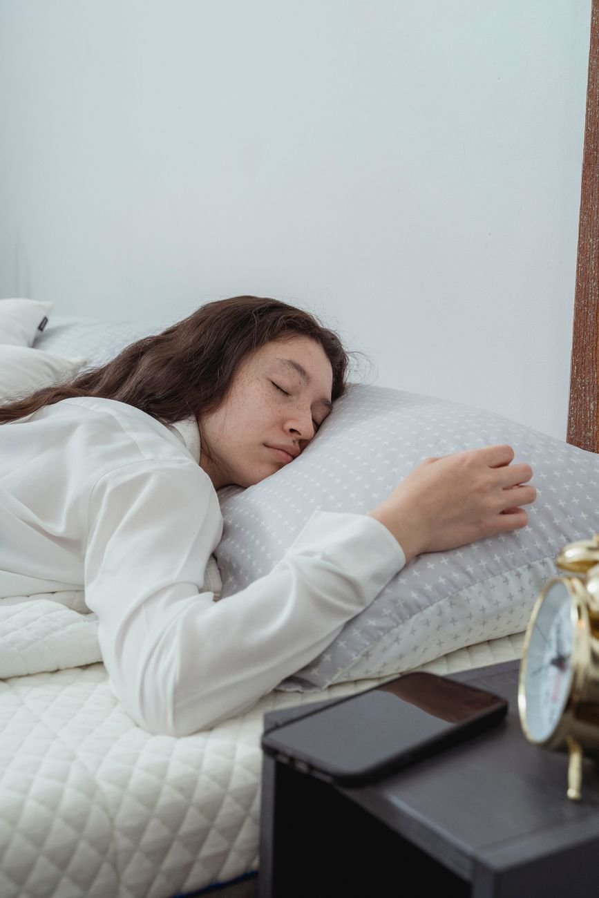 calm young female sleeping peacefully on bed