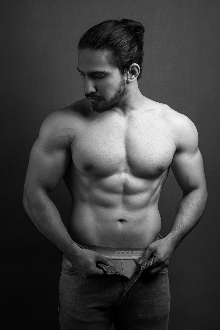 grayscale photo of a man taking off his pants