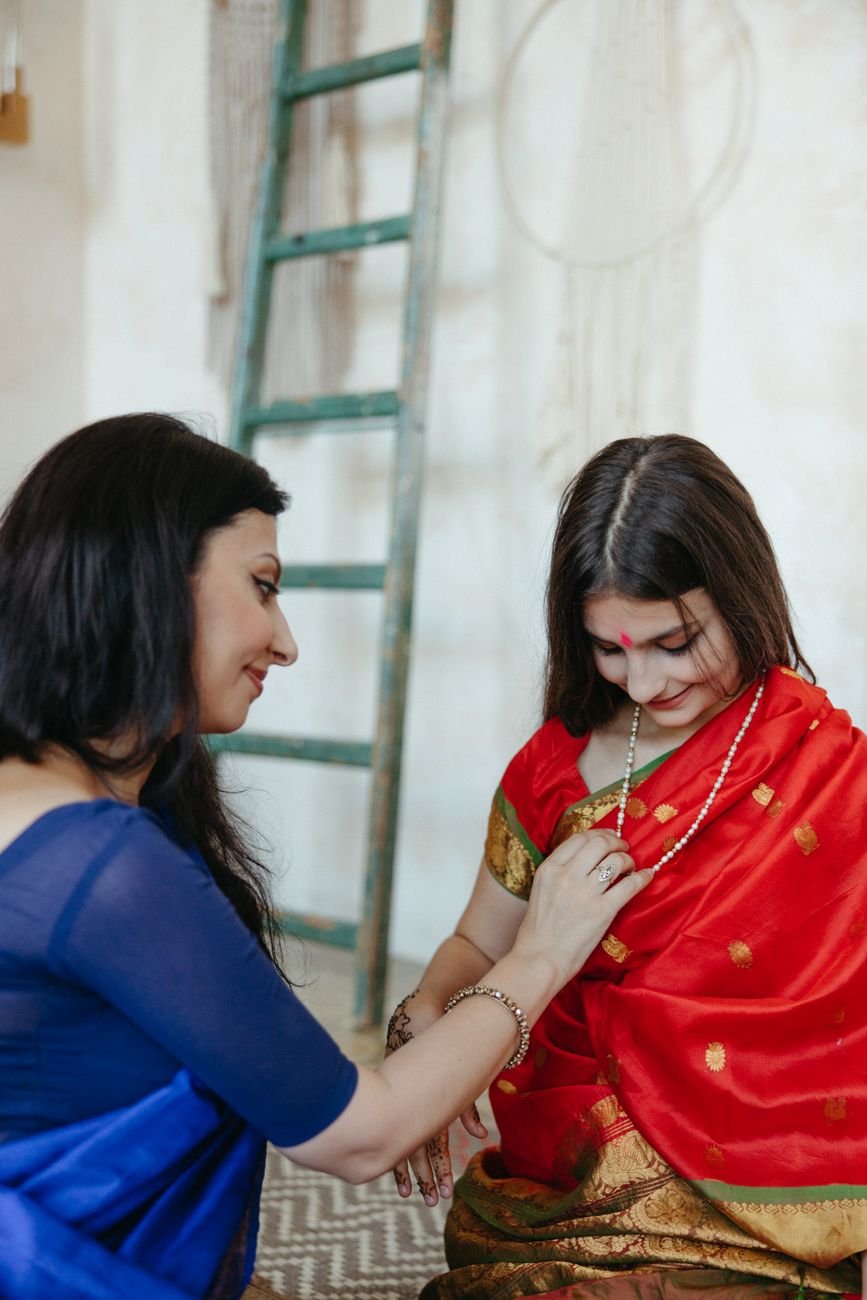 mother helping daughter with dress