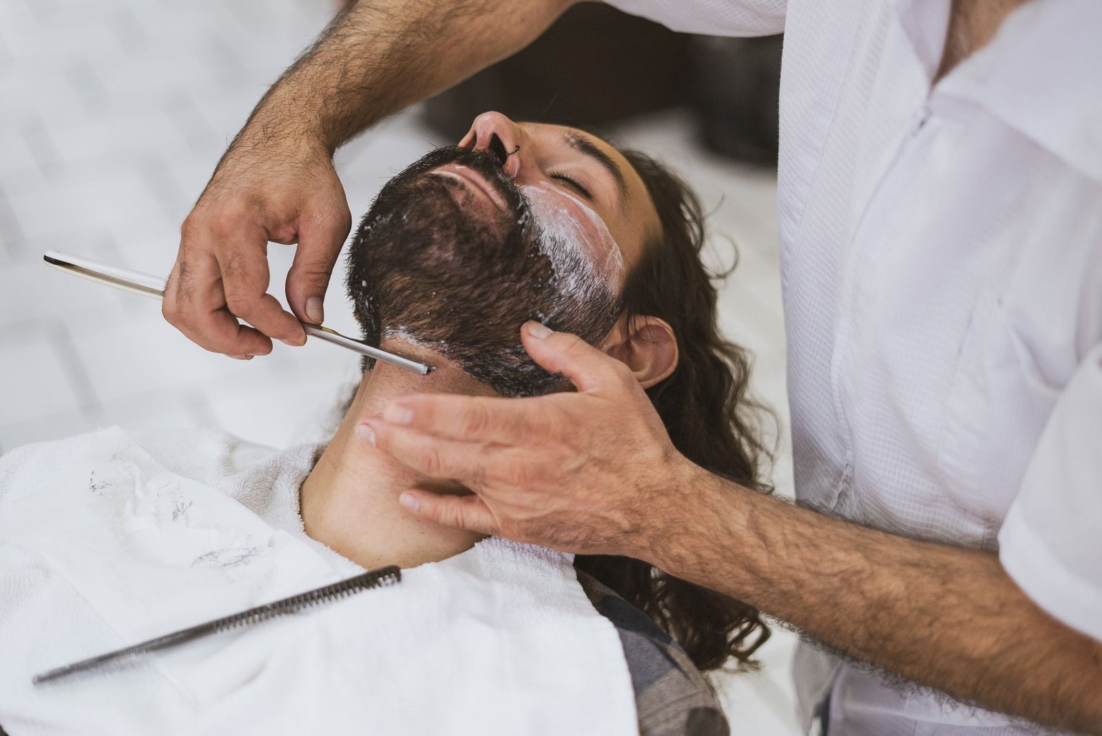 man getting his beard shaved
