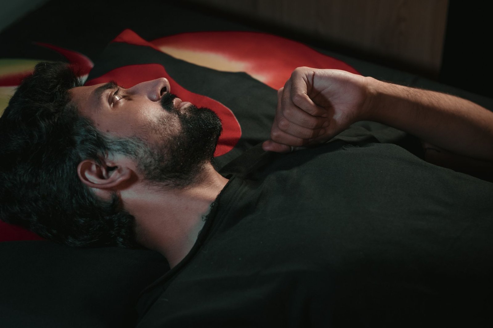 bearded man in black shirt lying