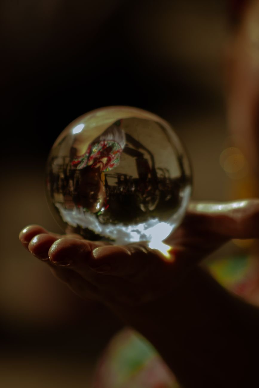 person holding clear glass ball