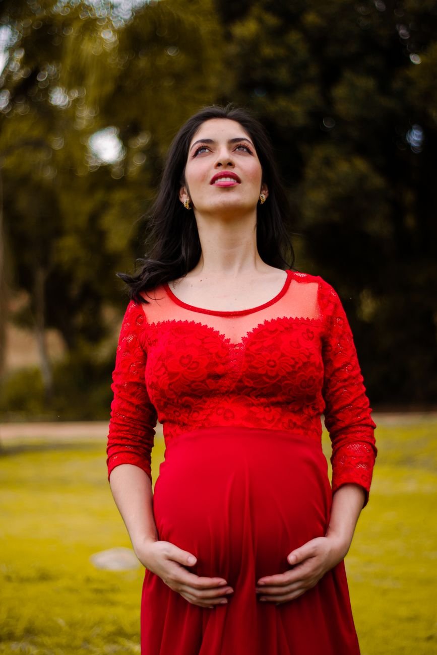 pregnant woman standing in red dress