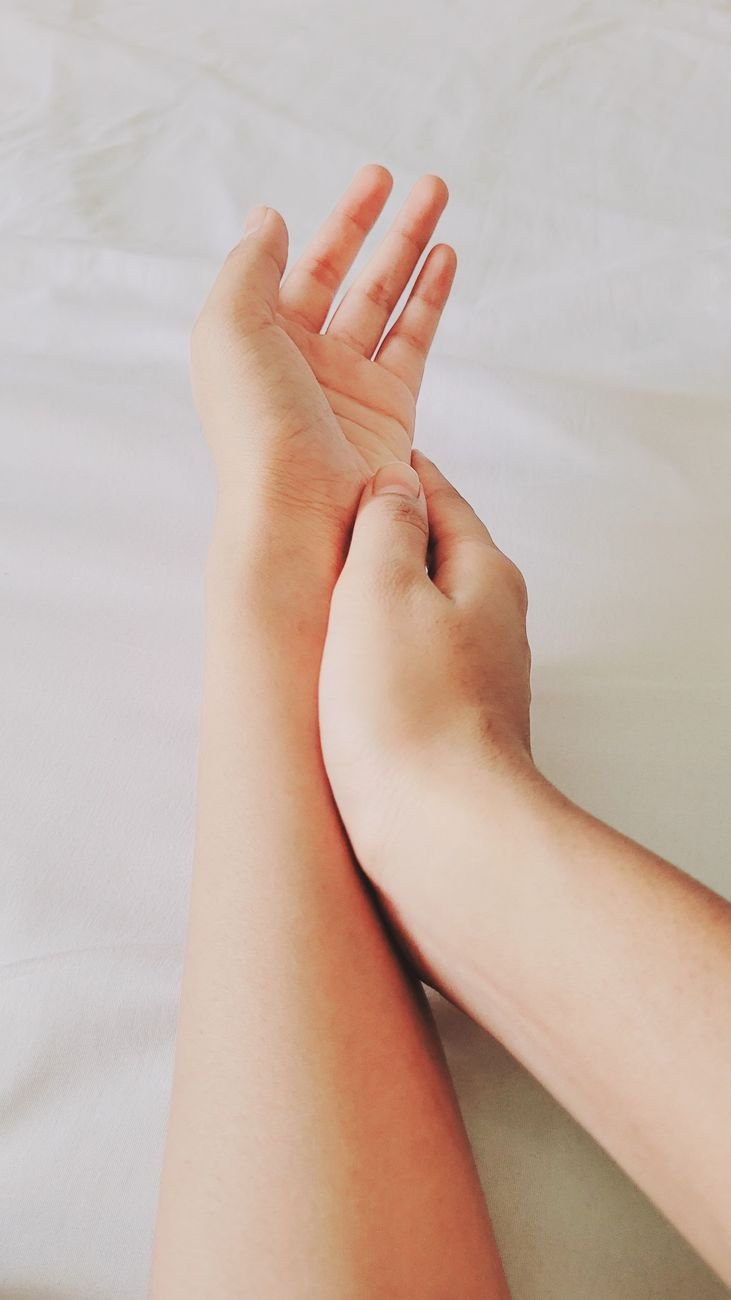 man and woman touching hands on a bed