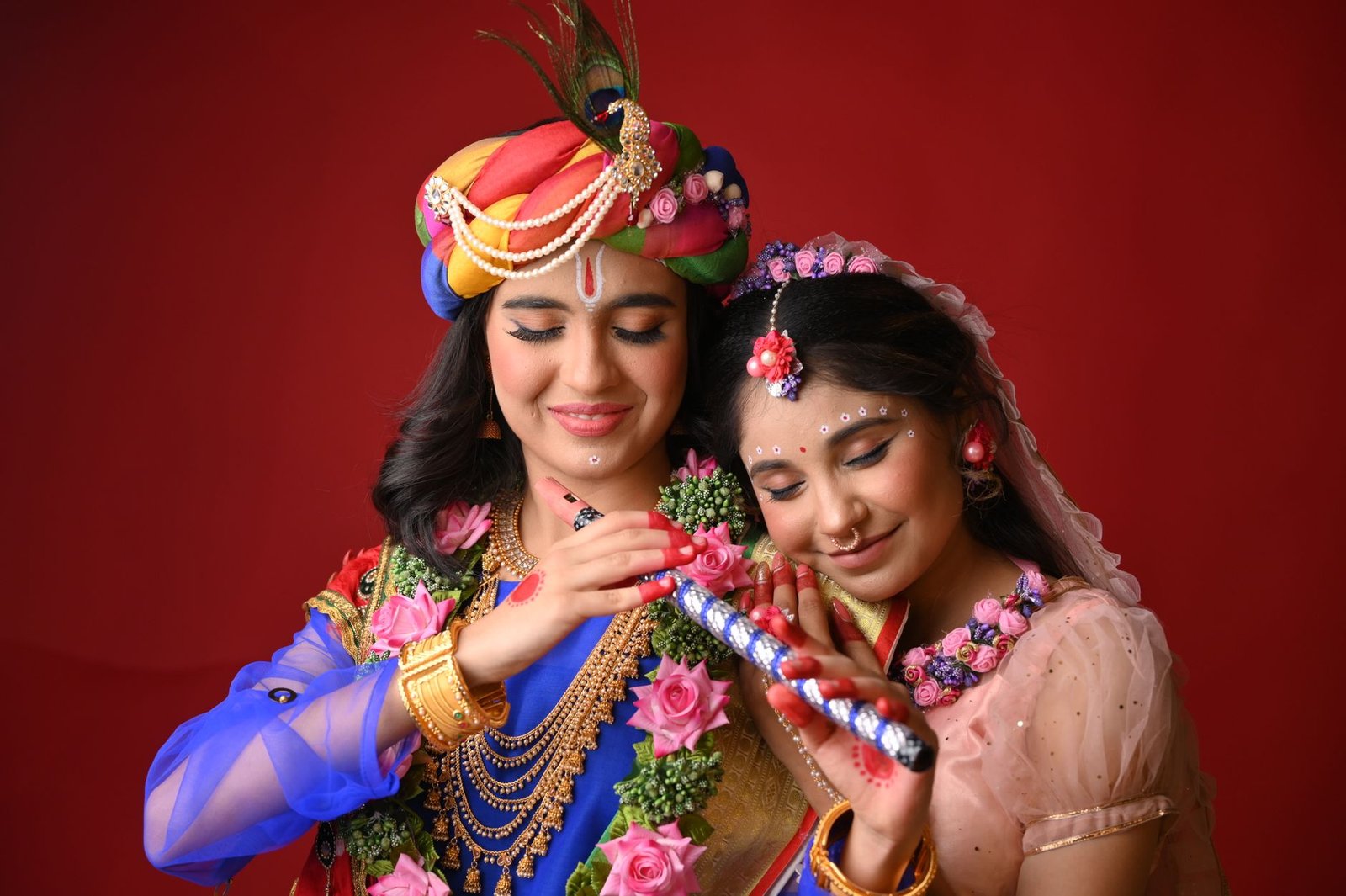smiling young women dressed as radha and krishna