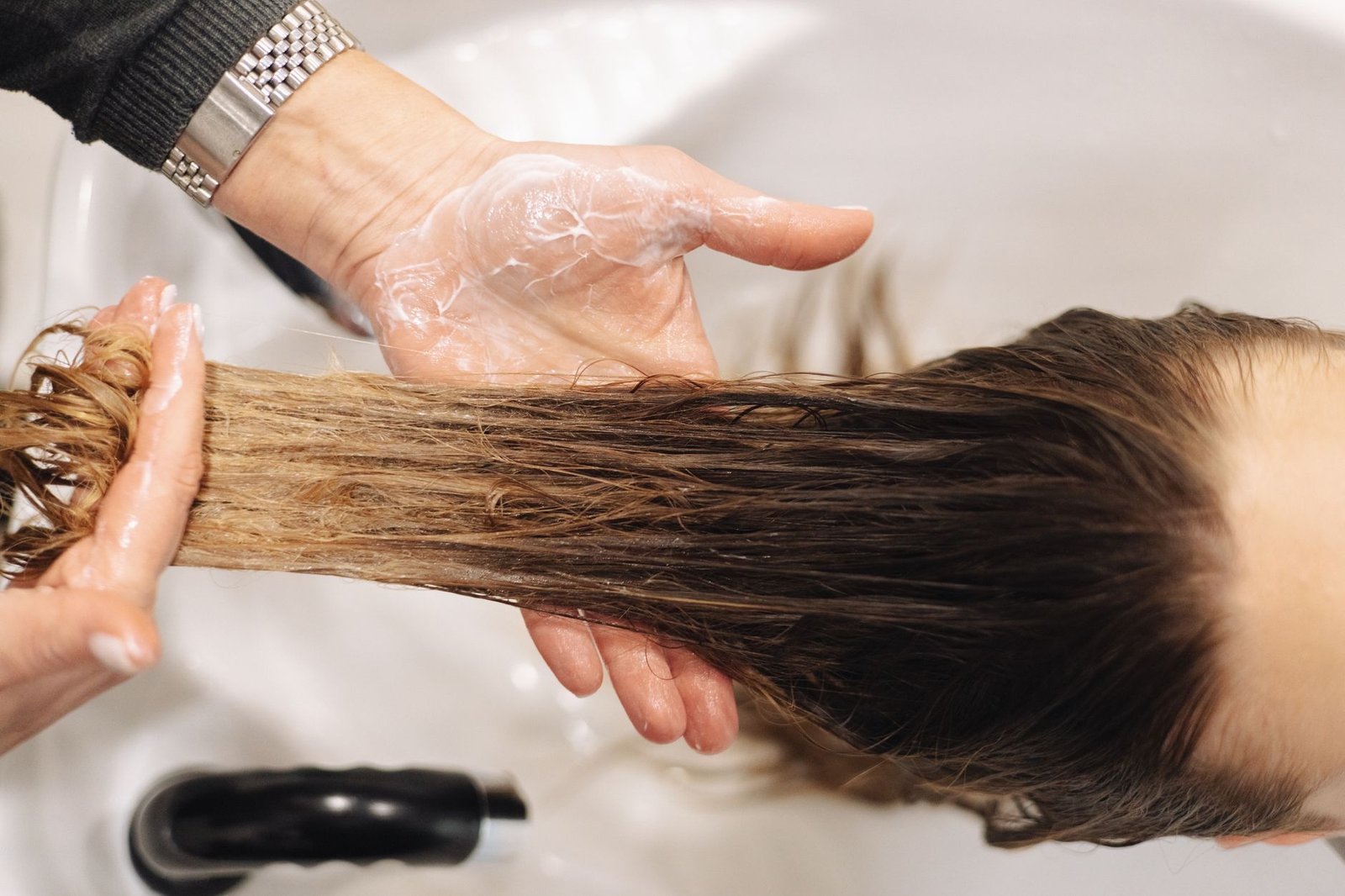 hairdresser washing customer hair