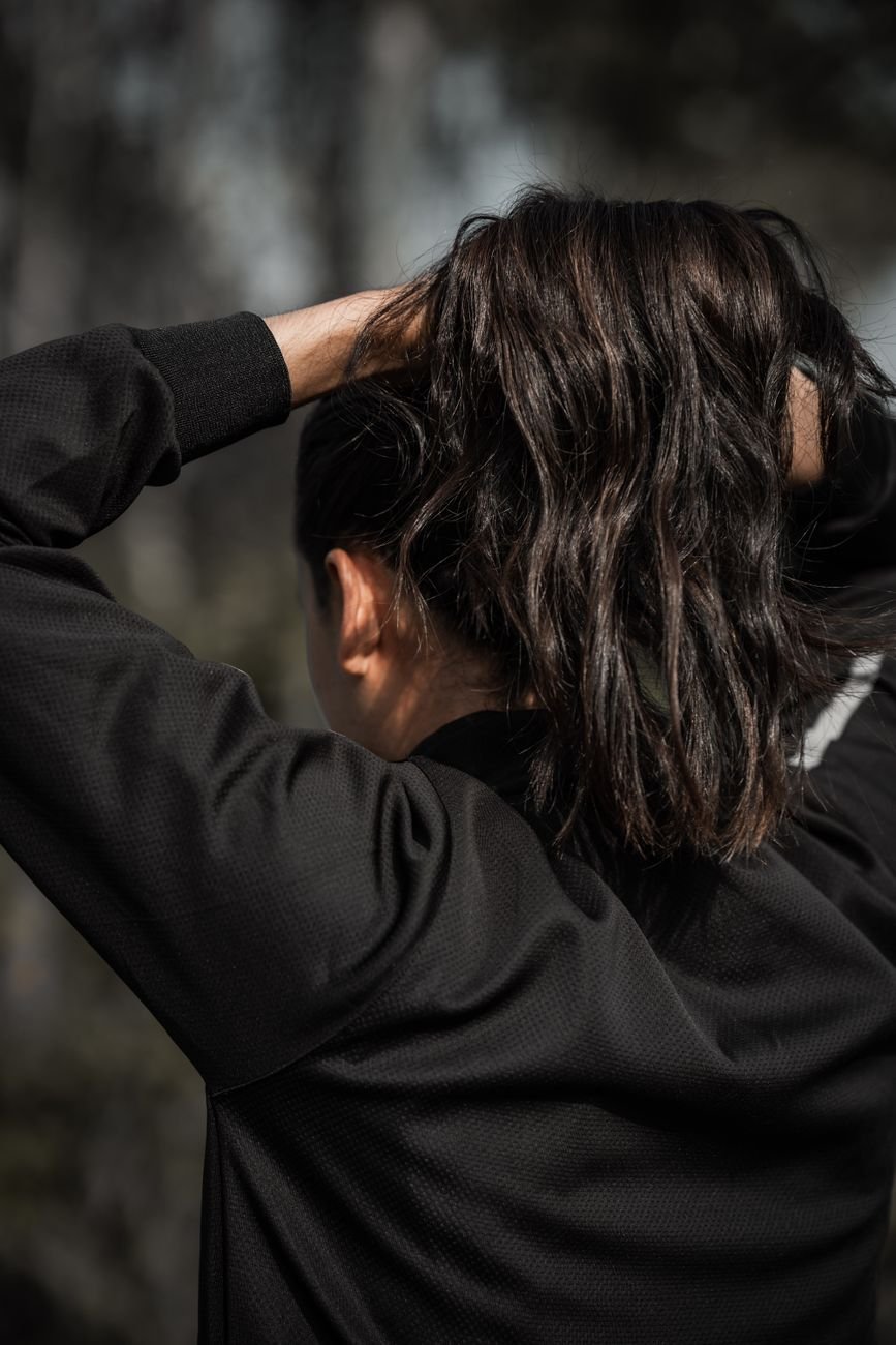 person fixing brunette hair