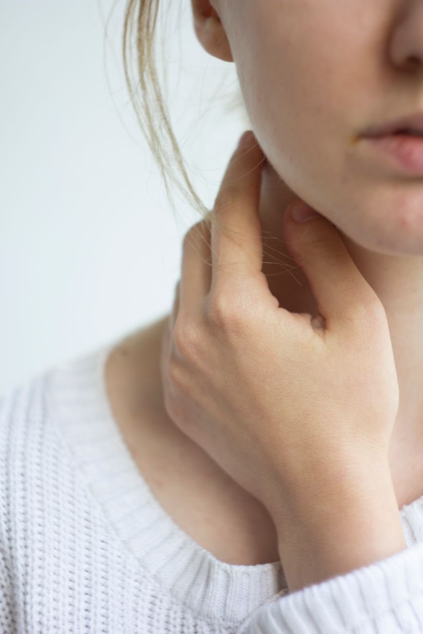 photo of woman touching her neck