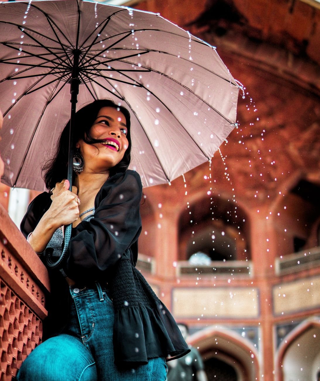 low angle view of woman holding umbrella under the rain