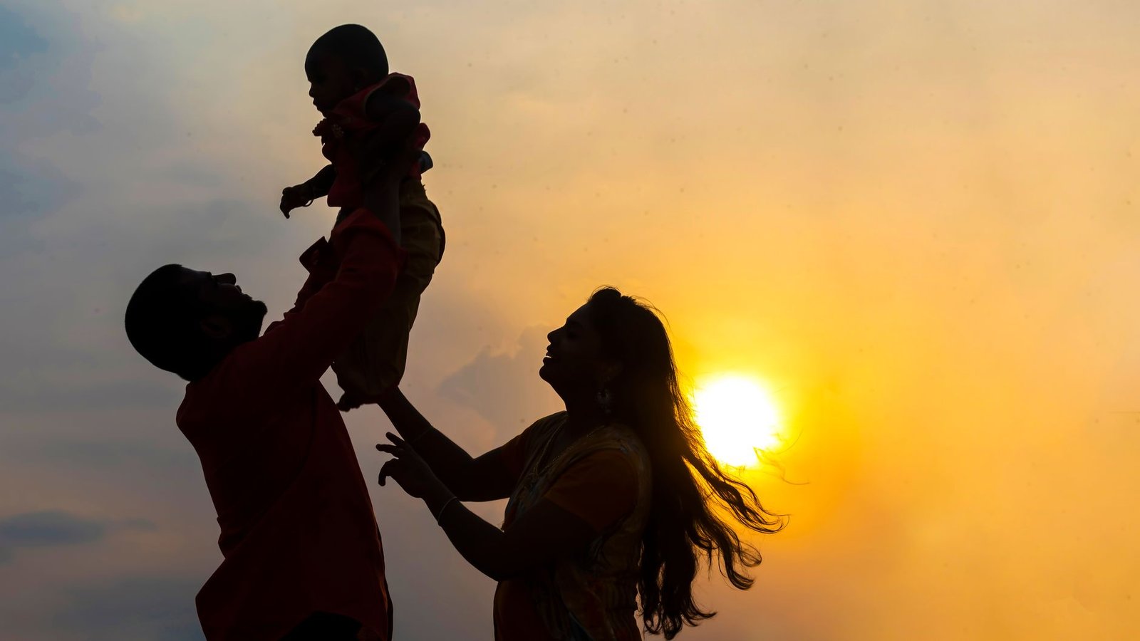 joyful family silhouette at sunset