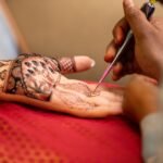 intricate henna art design being applied to hand
