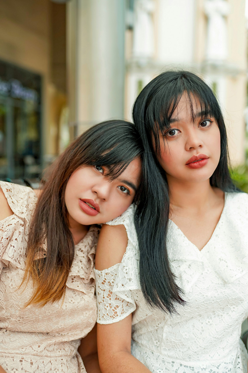 two woman leaning on eachother