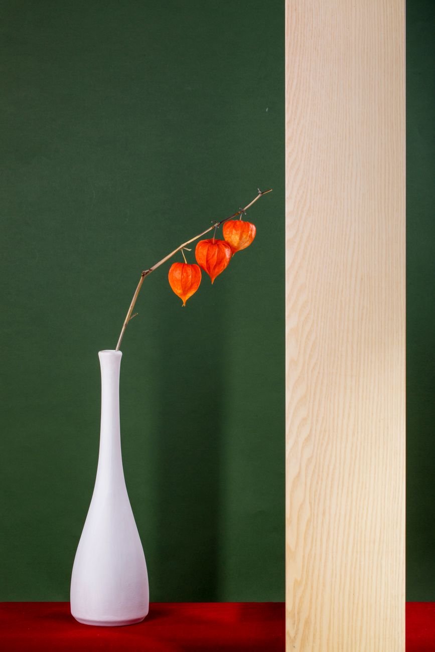 minimalist still life with vase and orange lanterns