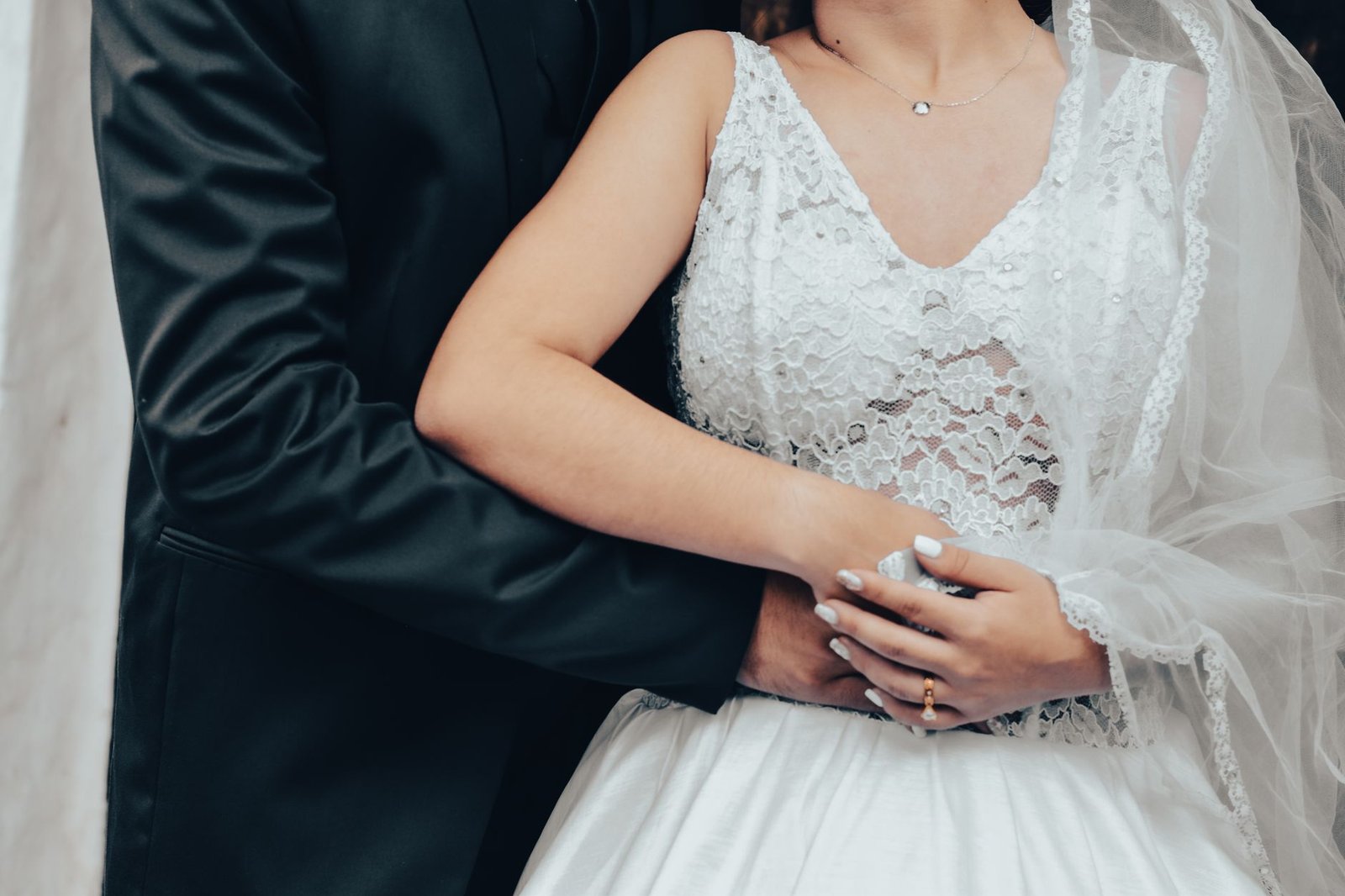 elegant wedding embrace in lace and tuxedo