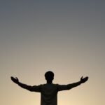 silhouette of man with arms outstretched
