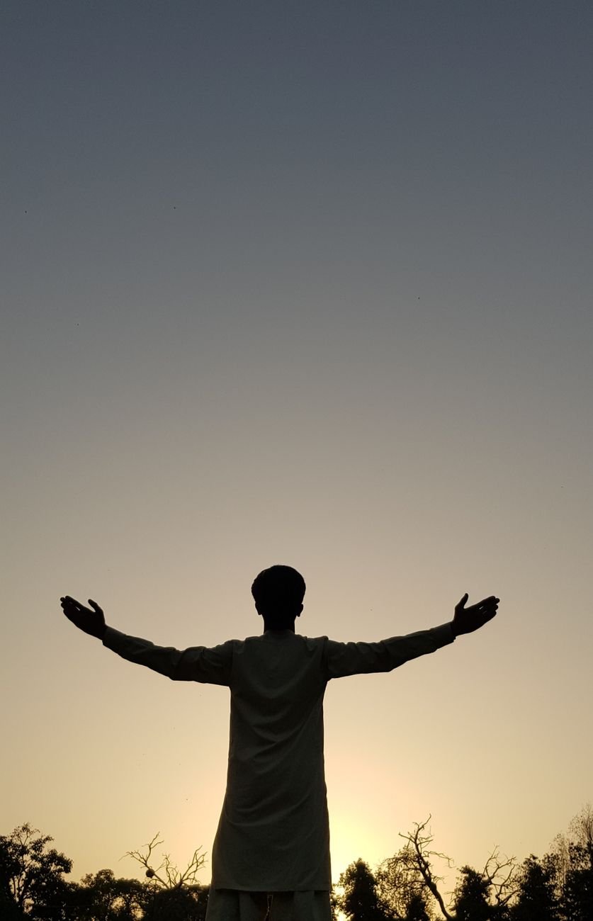 silhouette of man with arms outstretched