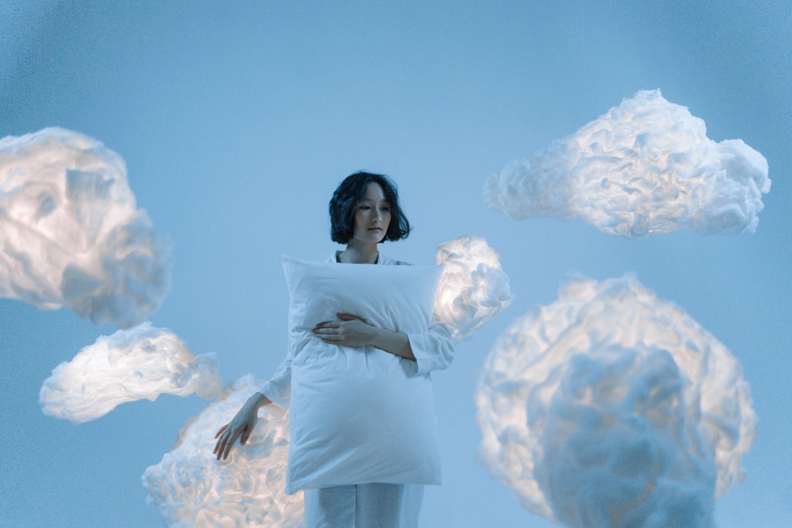 woman holding a pillow near clouds