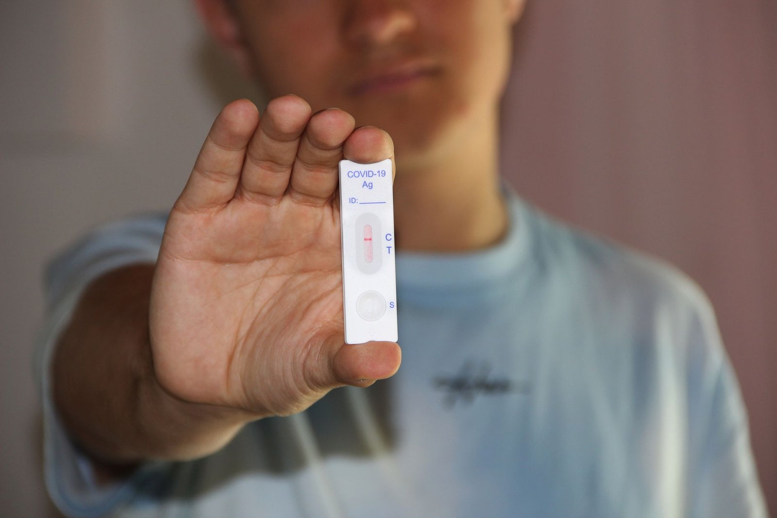 a man holding a result of antigen test