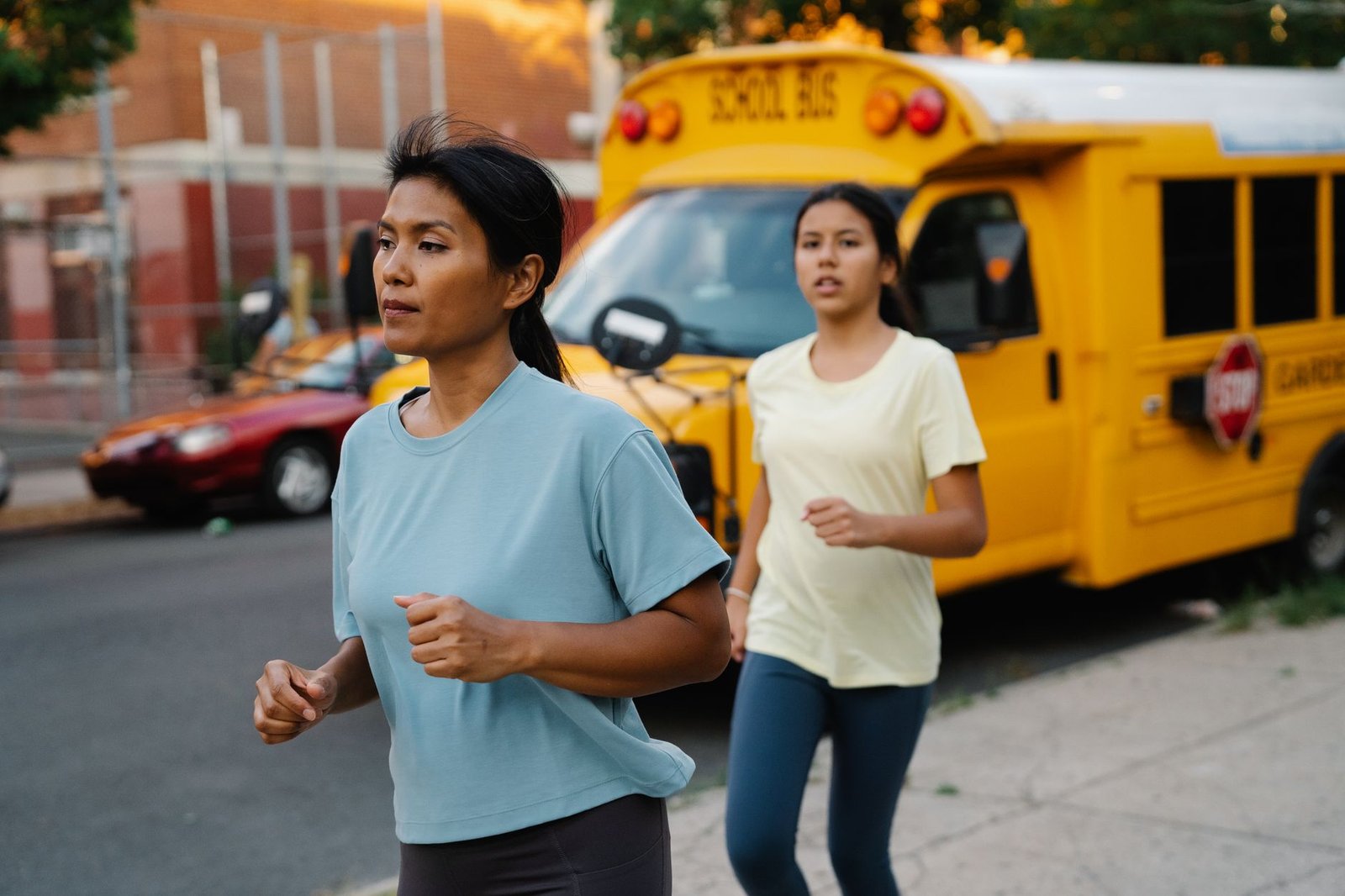 mother and daughter out on a run in city