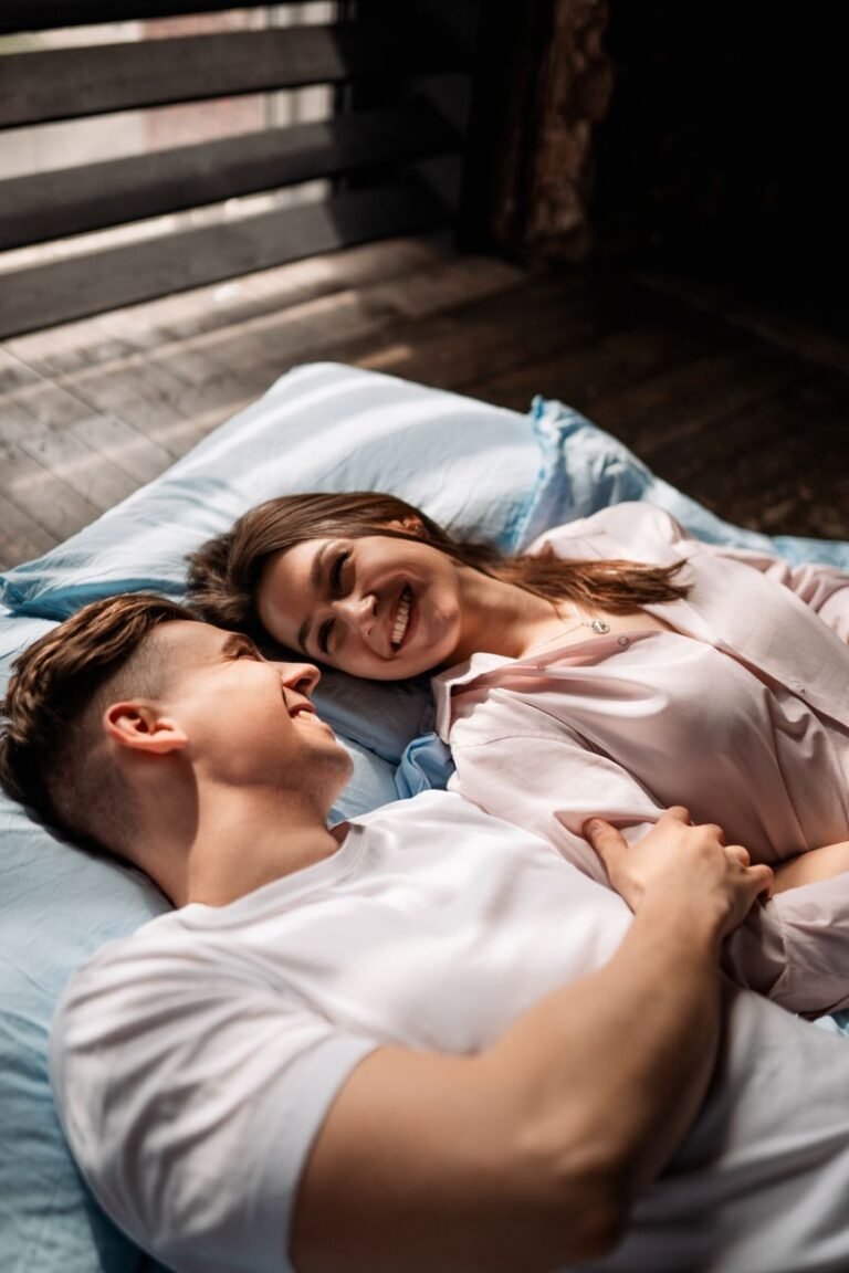 young couple lying on bed and looking at each other
