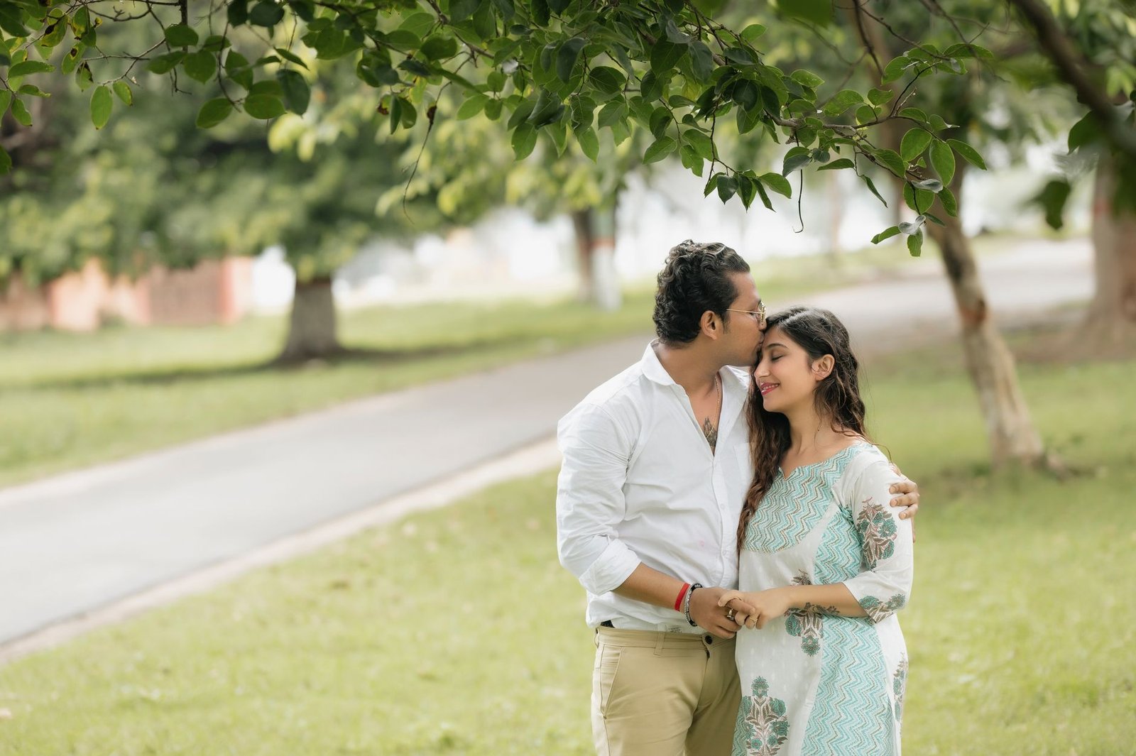 romantic couple embracing in a lush park setting