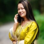 smiling woman in traditional dress talking on phone