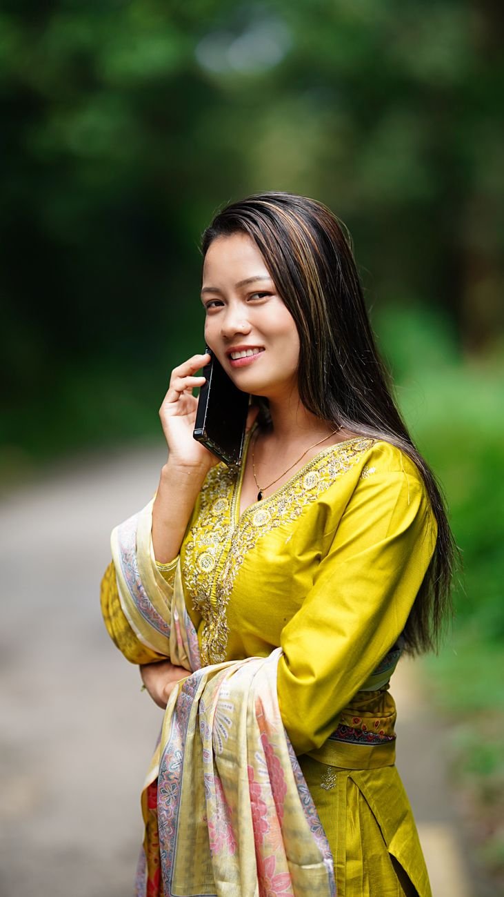 smiling woman in traditional dress talking on phone