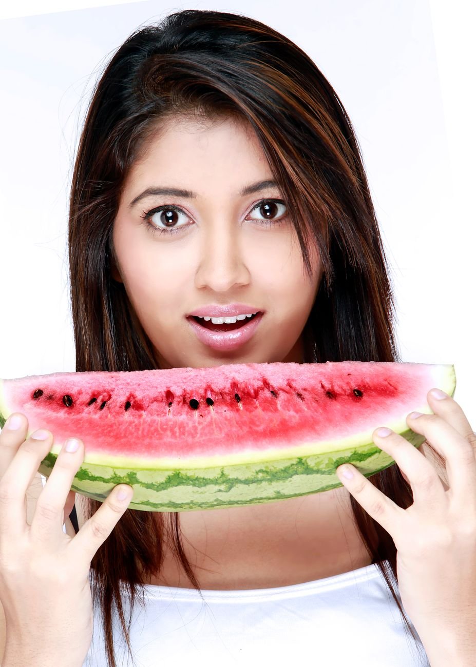 smiling woman holding a slice of watermelon