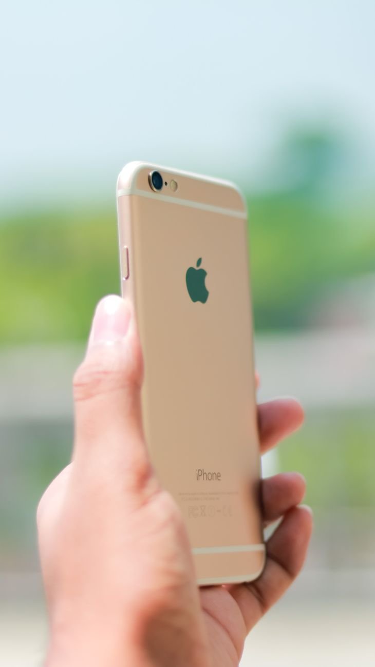gold iphone on person s hand
