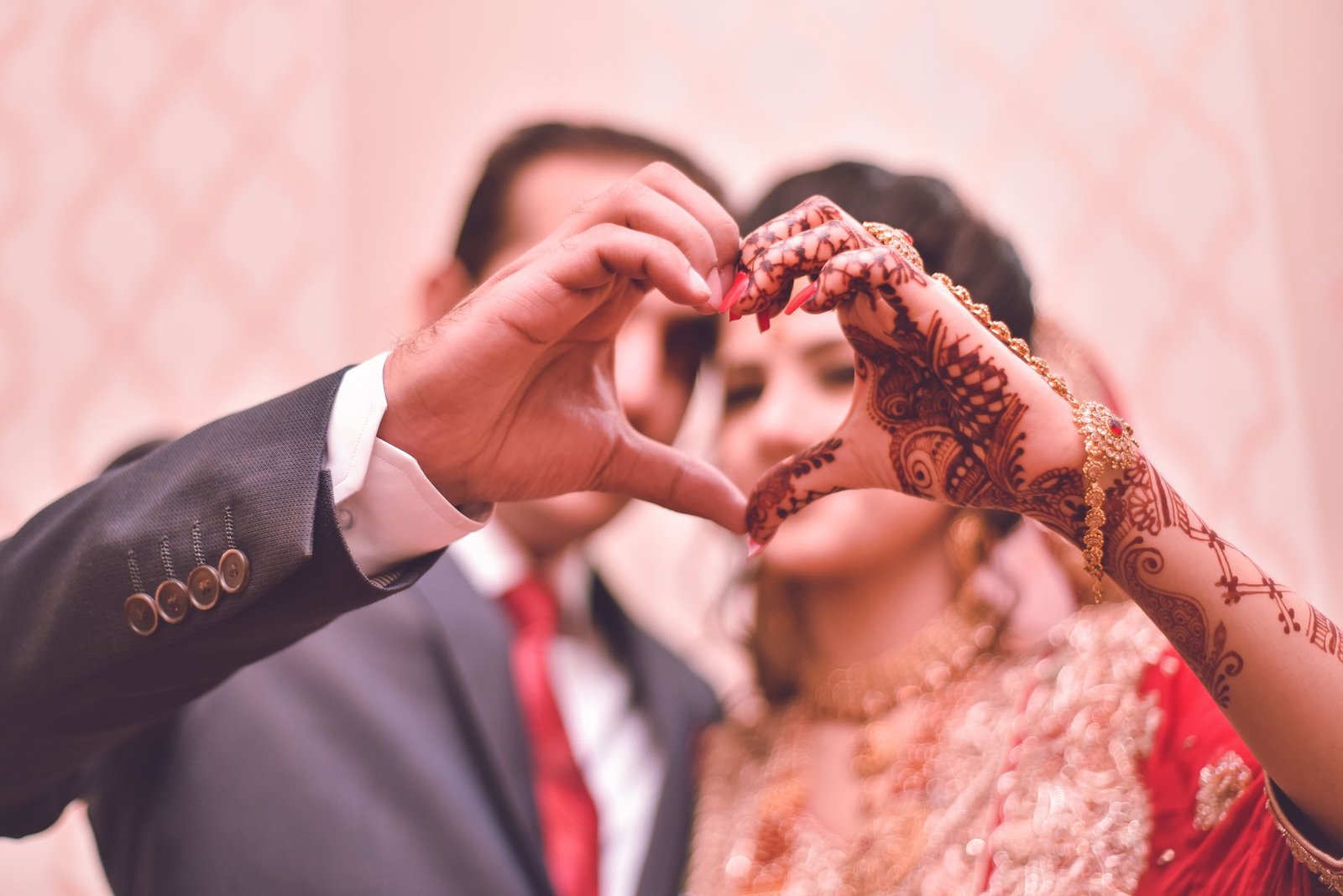 a newlywed couple doing the heart sign together