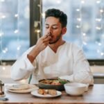 man using his hand while eating