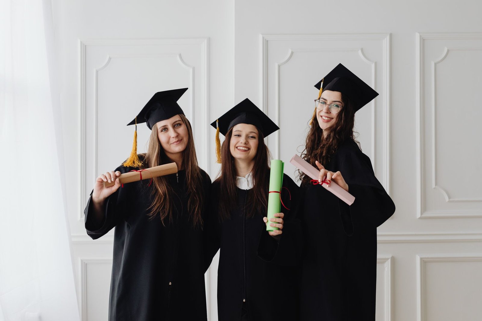 photo of women holding their diplomas