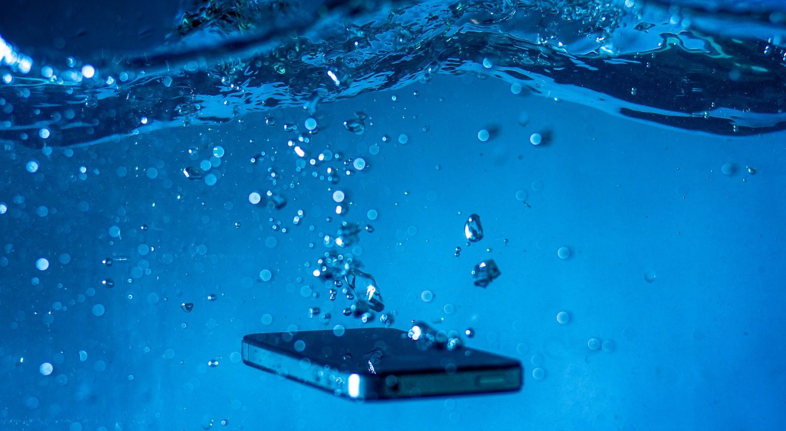 black mobile phone under blue water